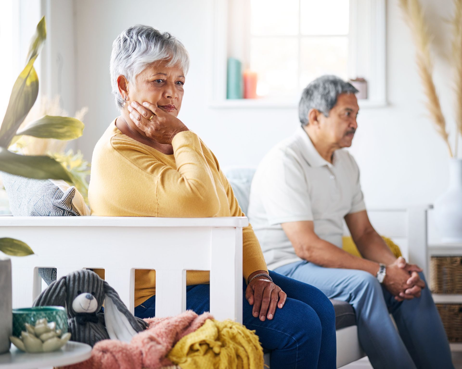 An older couple sitting together but looking in different directions, representing the unique grief 