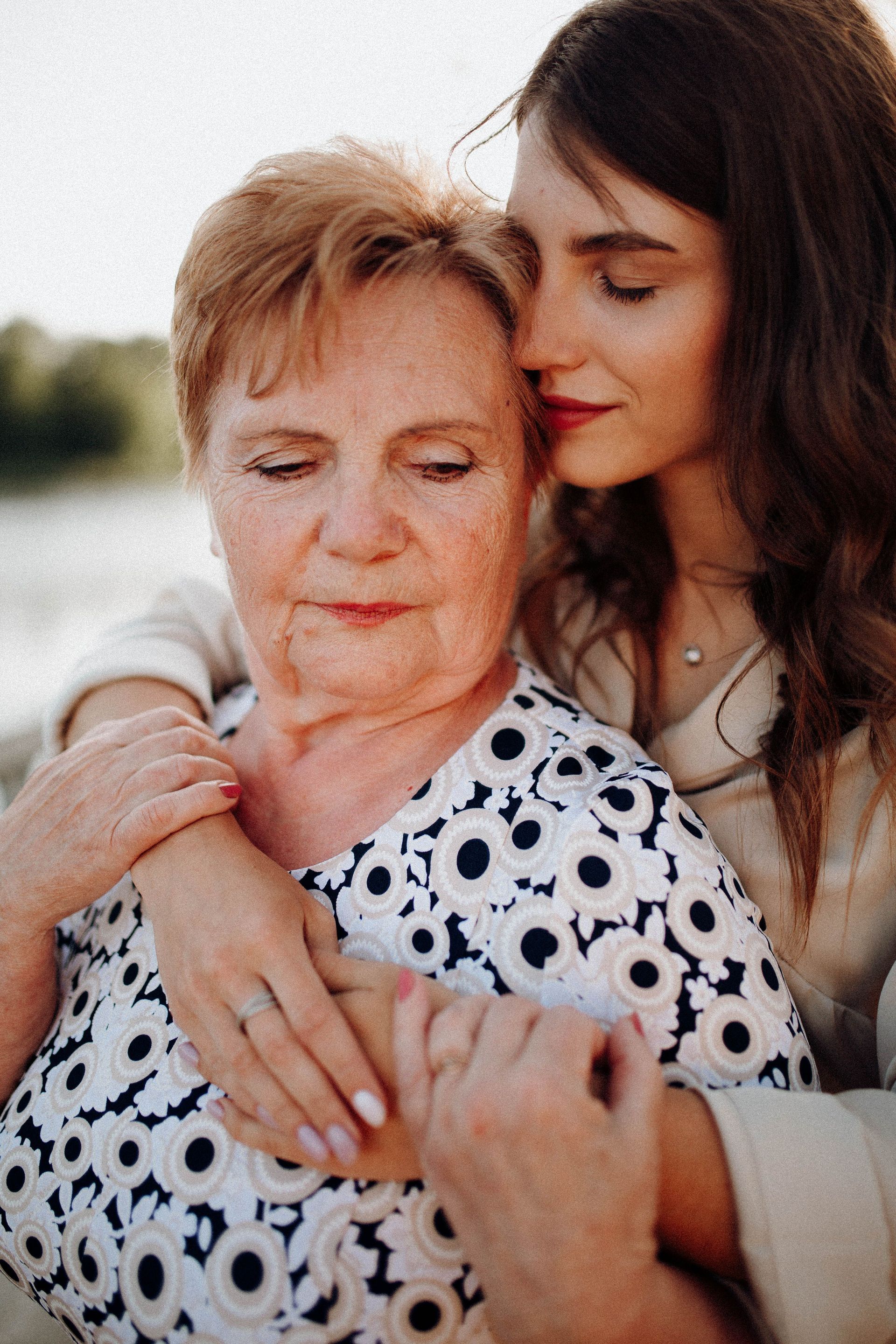 Adult daughter embracing her elderly mother, a family dementia caregiver