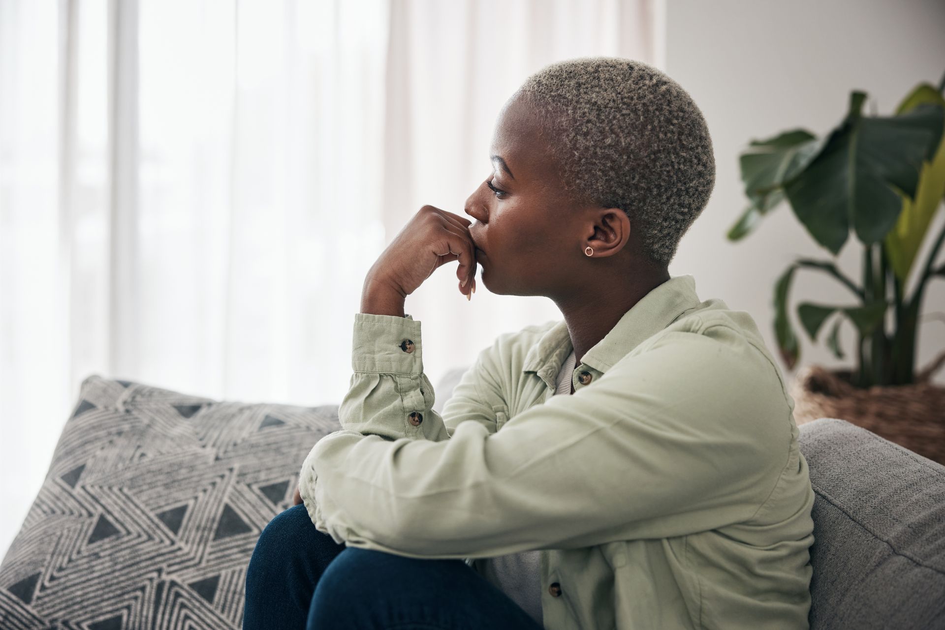 Exhausted family caregiver sitting alone, showing signs of caregiver burnout