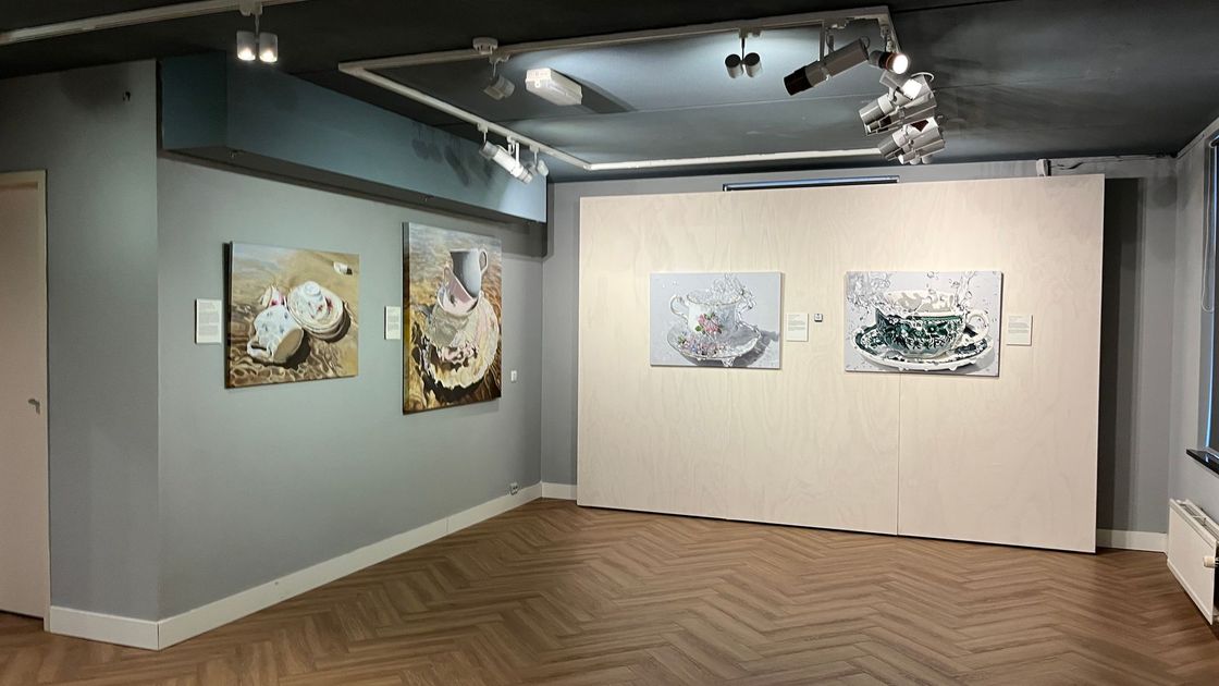 Interieur van het Huizer  Museum met ingelijste schilderijen aan grijze en crèmekleurige muren onder plafondspots.