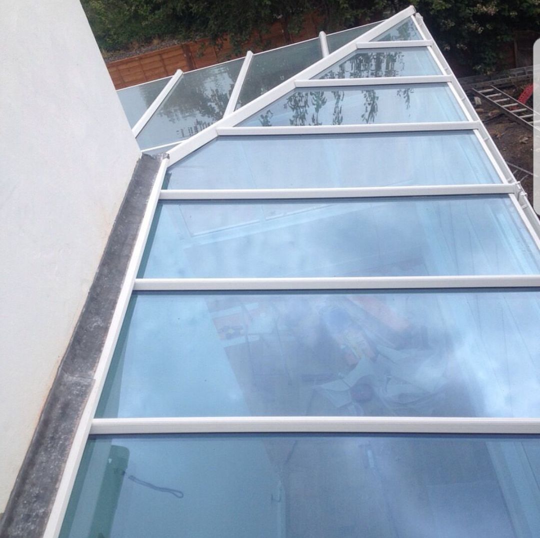 A clear glass roof with a white frame