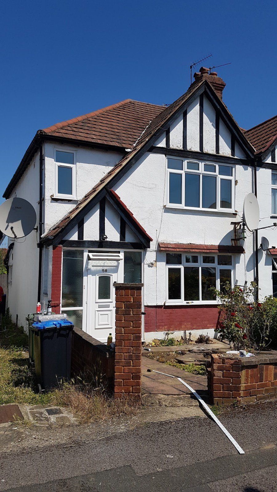 A white and red house with a satellite dish on the roof