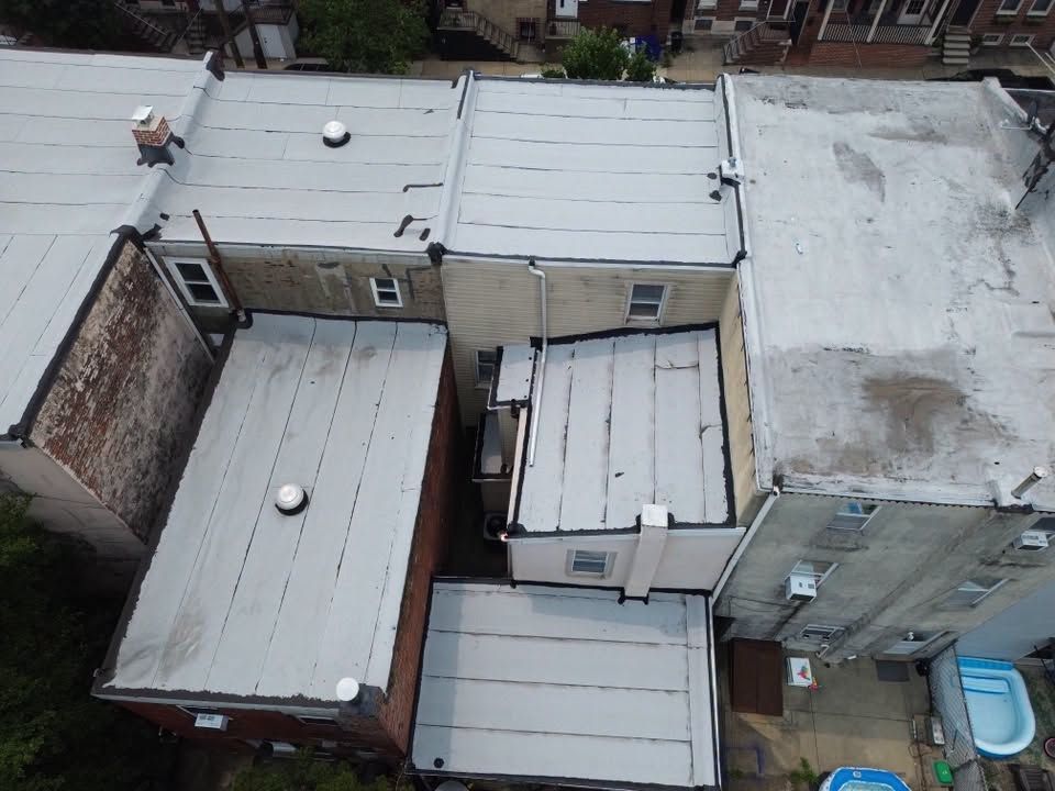 Aerial view of tightly packed flat-roofed buildings in a narrow urban alley.