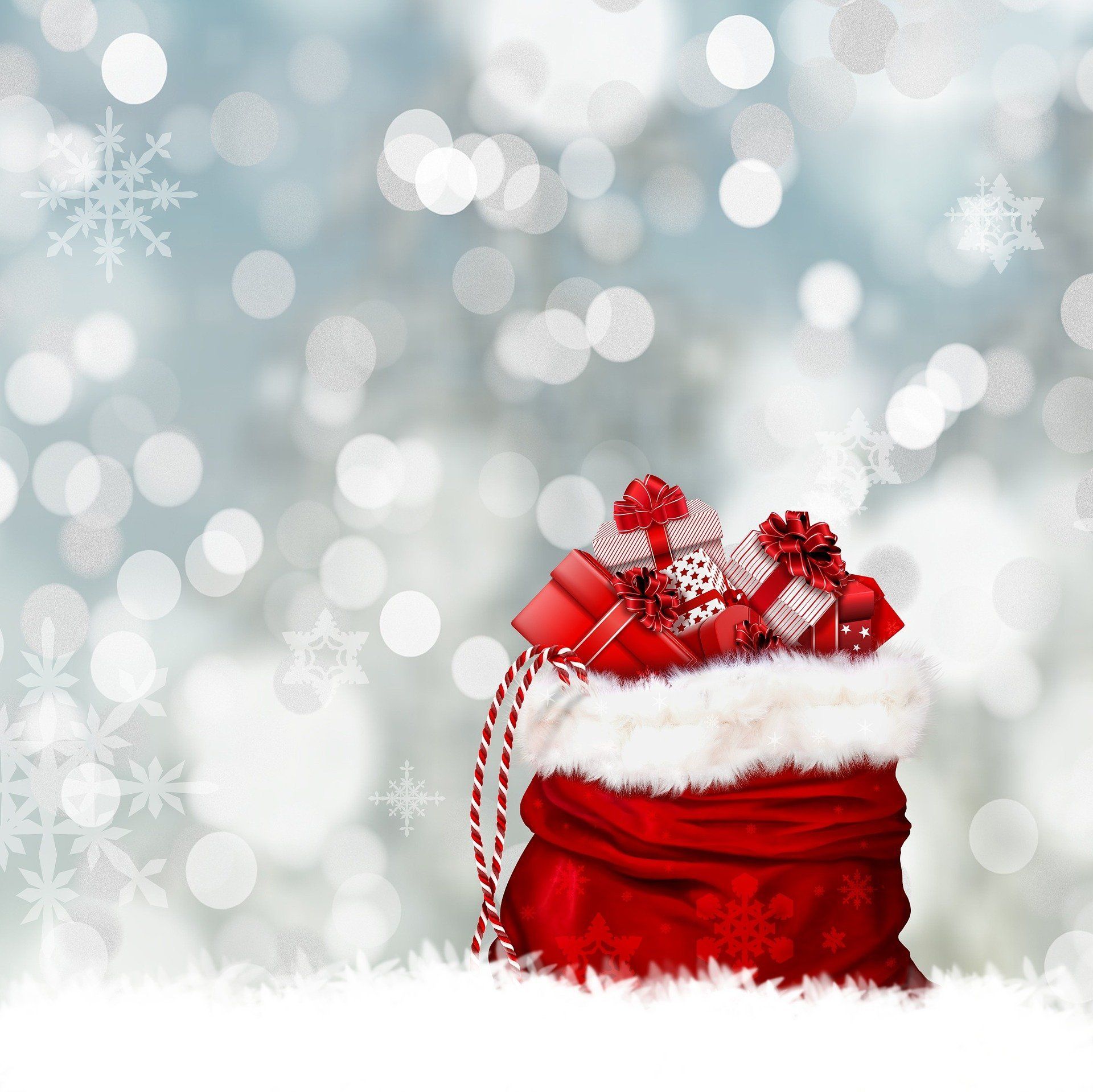 Santa's sack overflowing with wrapped gifts, red and white, set in snow, against a bokeh background.