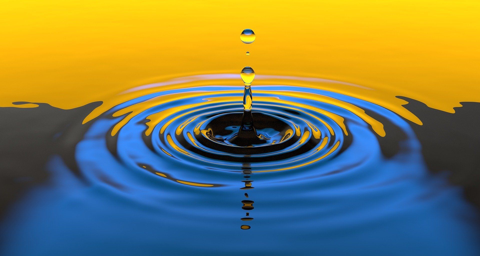 Water droplets falling into liquid, creating concentric ripples. Yellow and blue background.