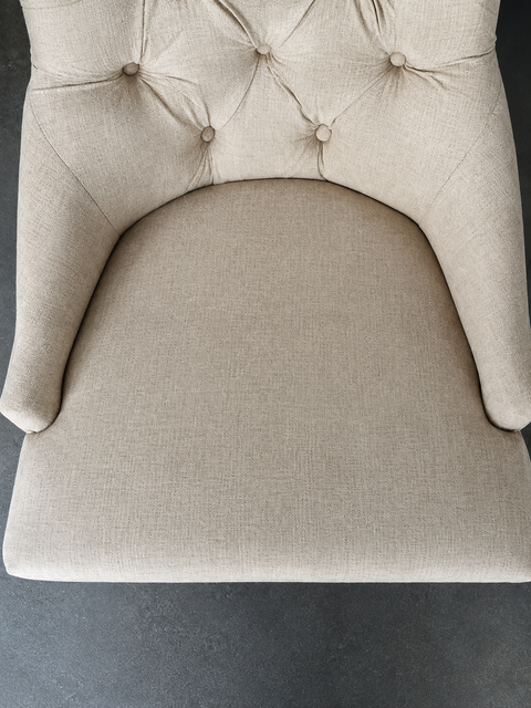 Patterned cushions and rug on a blue carpeted floor, with a table leg and a small blue bag nearby
