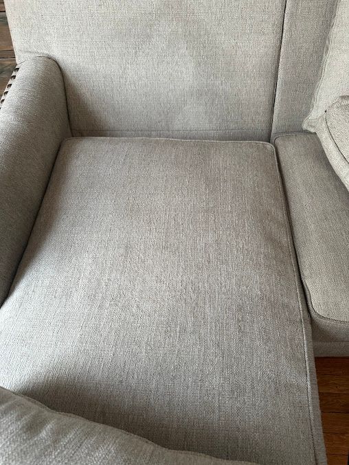 Light gray upholstered armchair with a wooden floor visible below.