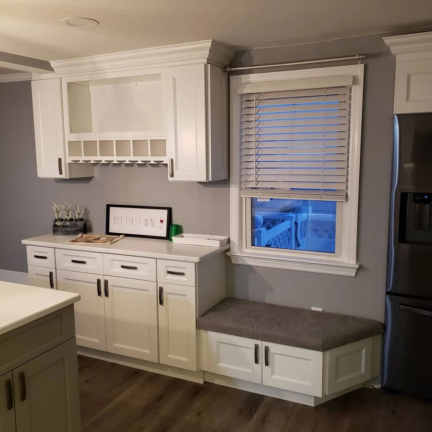 White kitchen with cabinets, countertops, and a window seat.