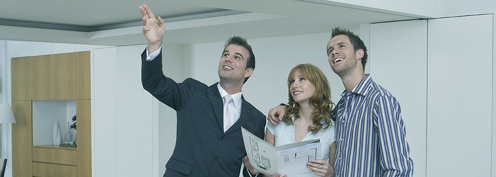 couple and estate agent looking at a property