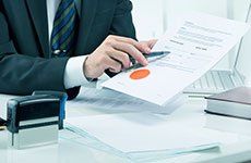 Man with pen pointing at paper