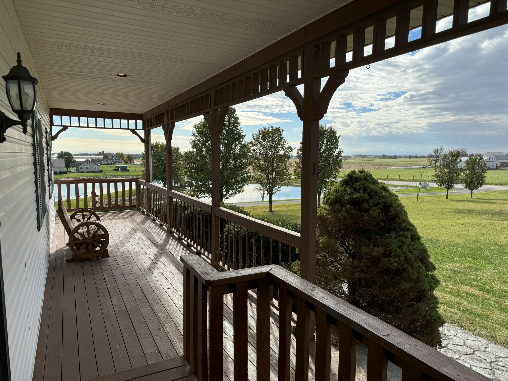 A porch with a view of a field and trees