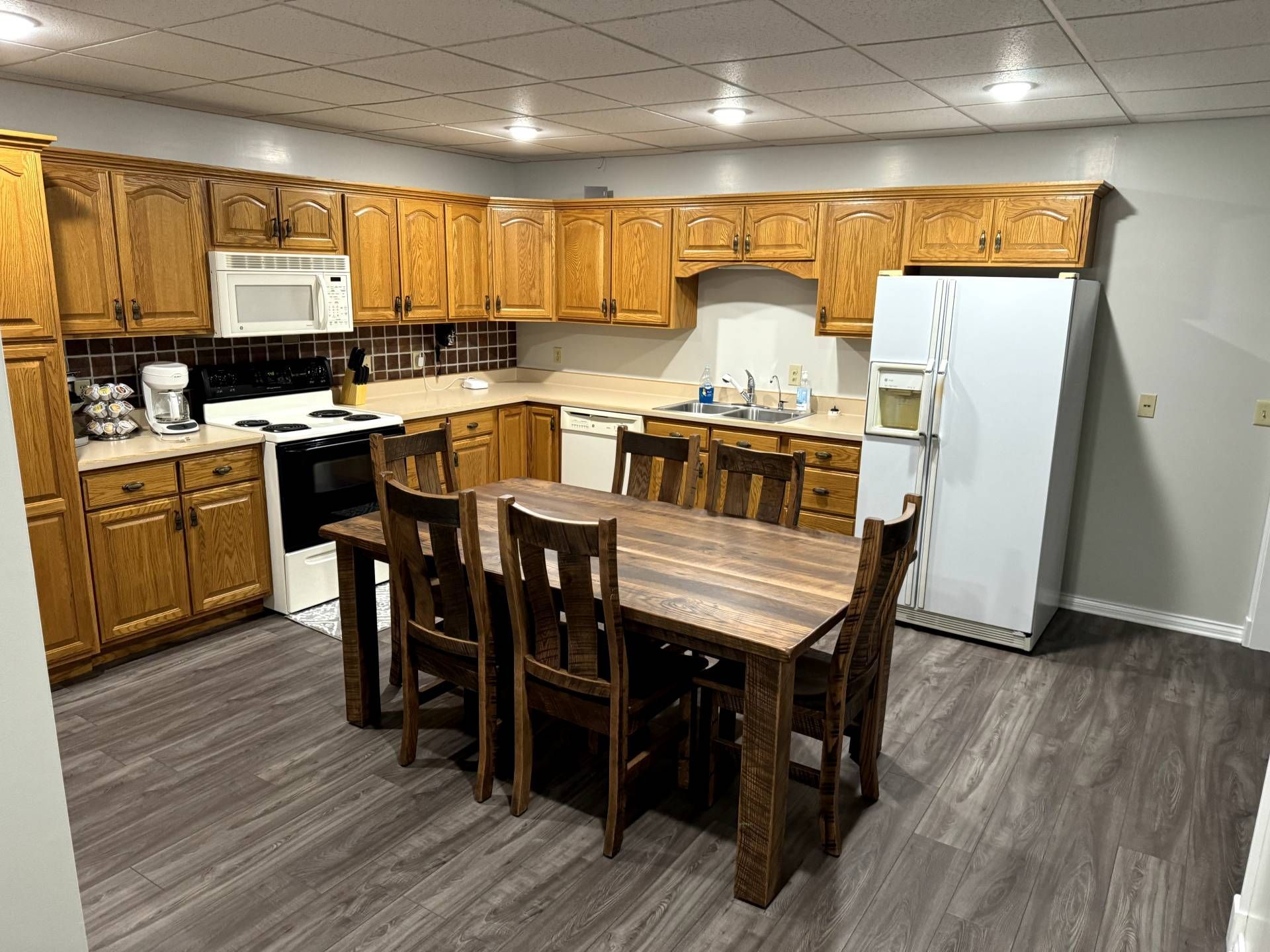 A kitchen with a table and chairs and a refrigerator.