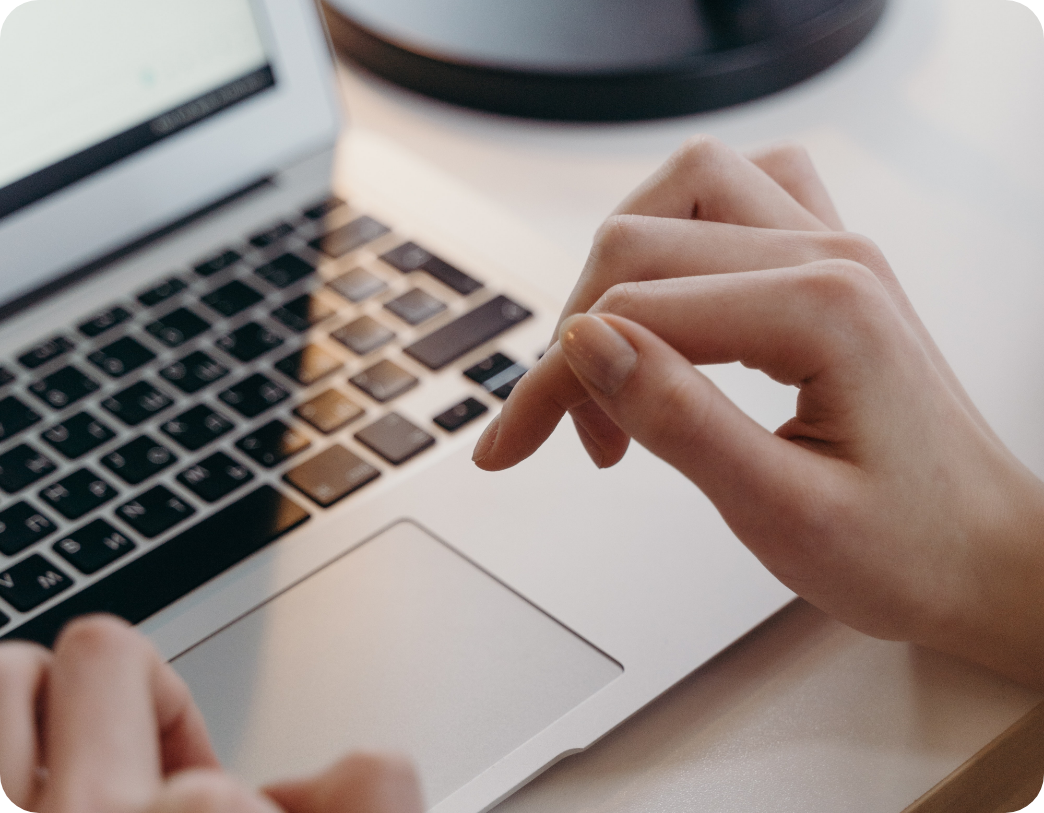 a woman's hands hovering over the keyboard of a MacBook