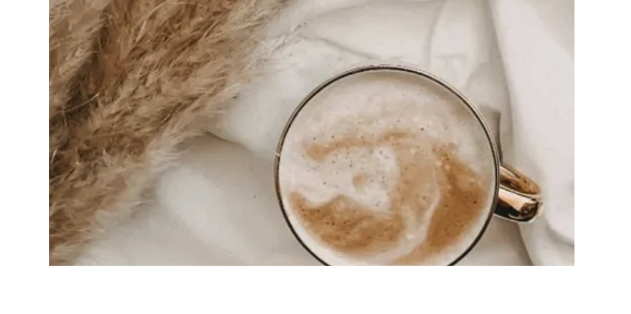 a cup of coffee on a white table cloth