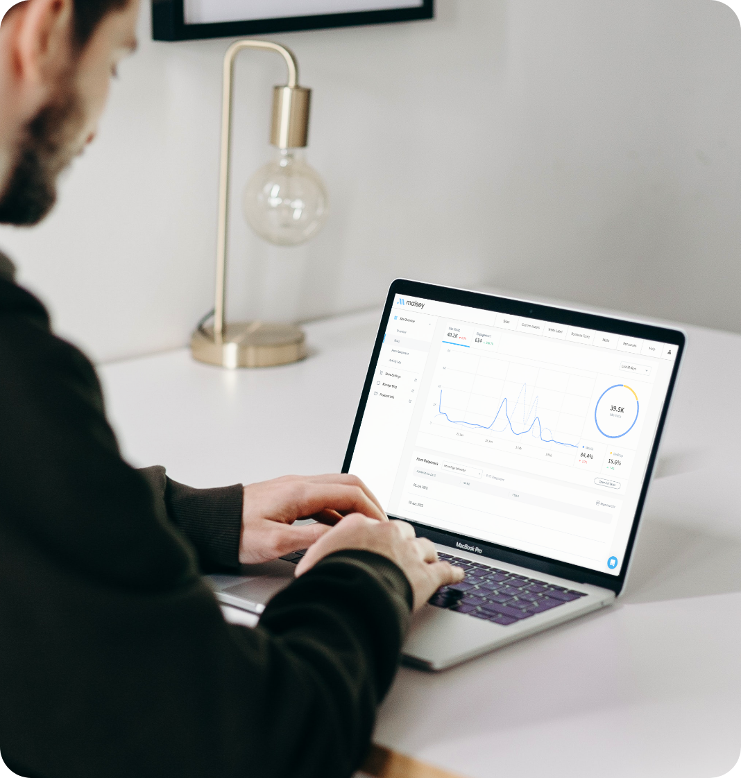 man looking at laptop screen showing data graphs