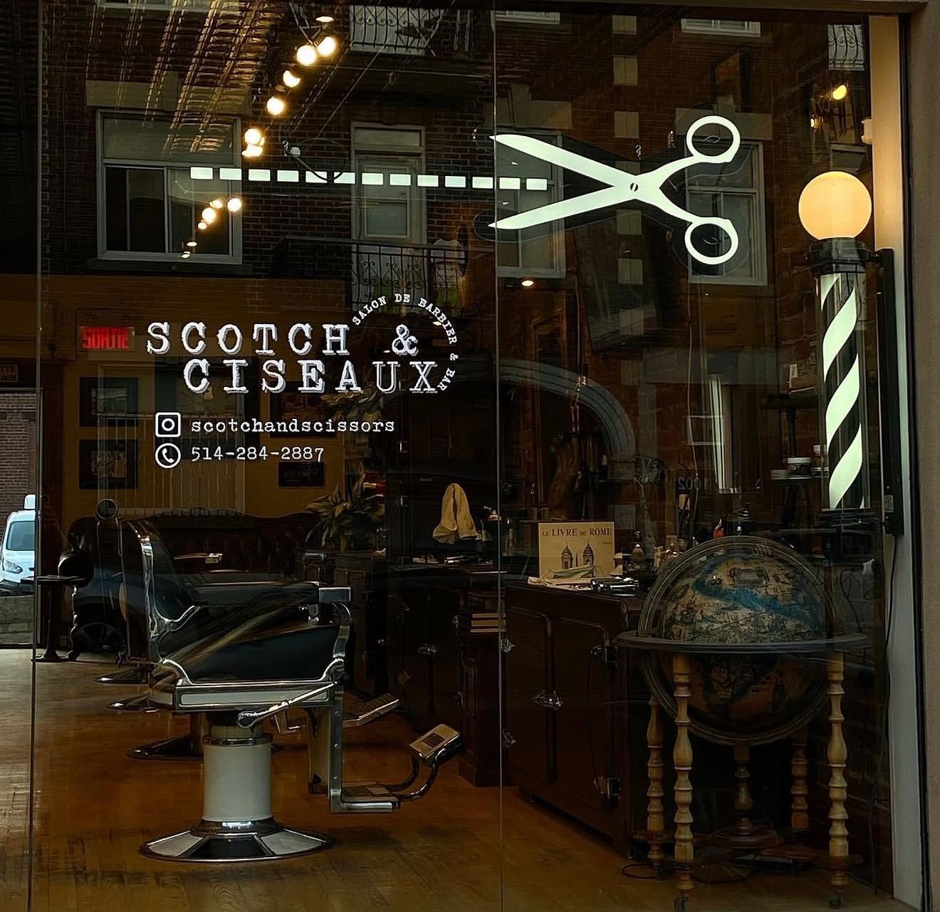 Barbershop storefront with glowing scissors sign and “Scotch Ciseaux” lettering on the window