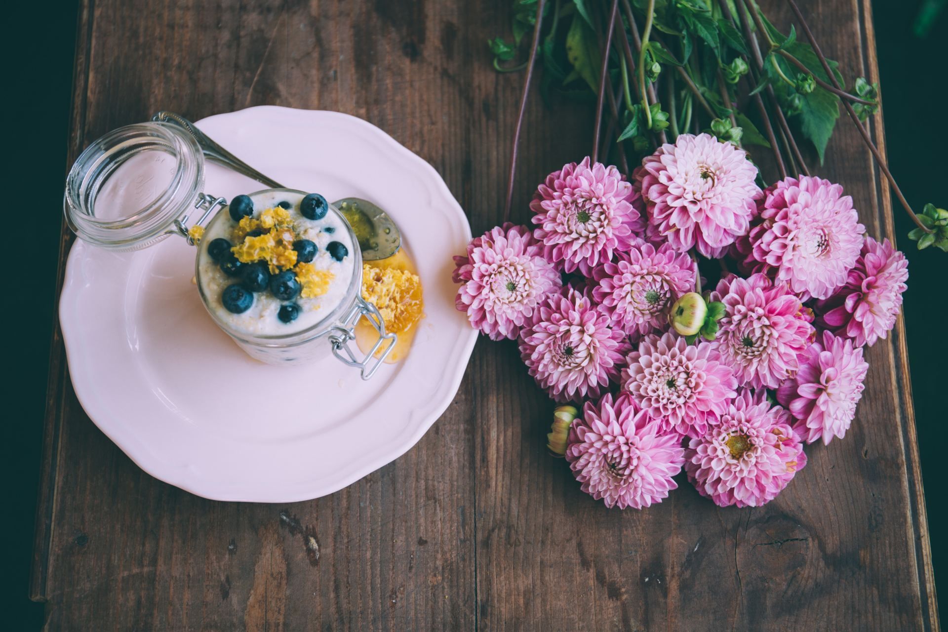 Havermoutpap met bosbessen en bloemen op een houten tafel.