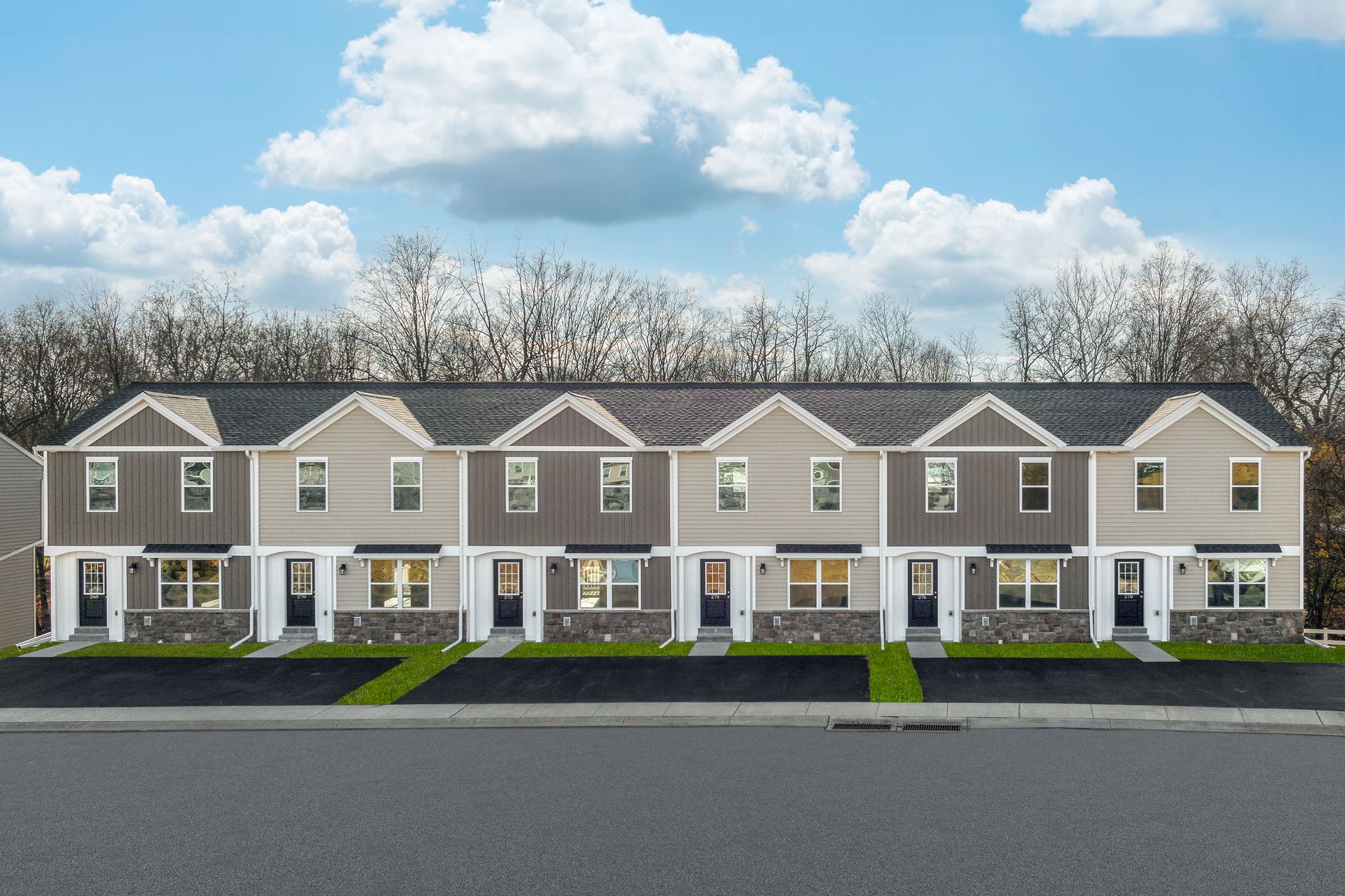 An artist 's impression of a row of townhouses with trees in the background.