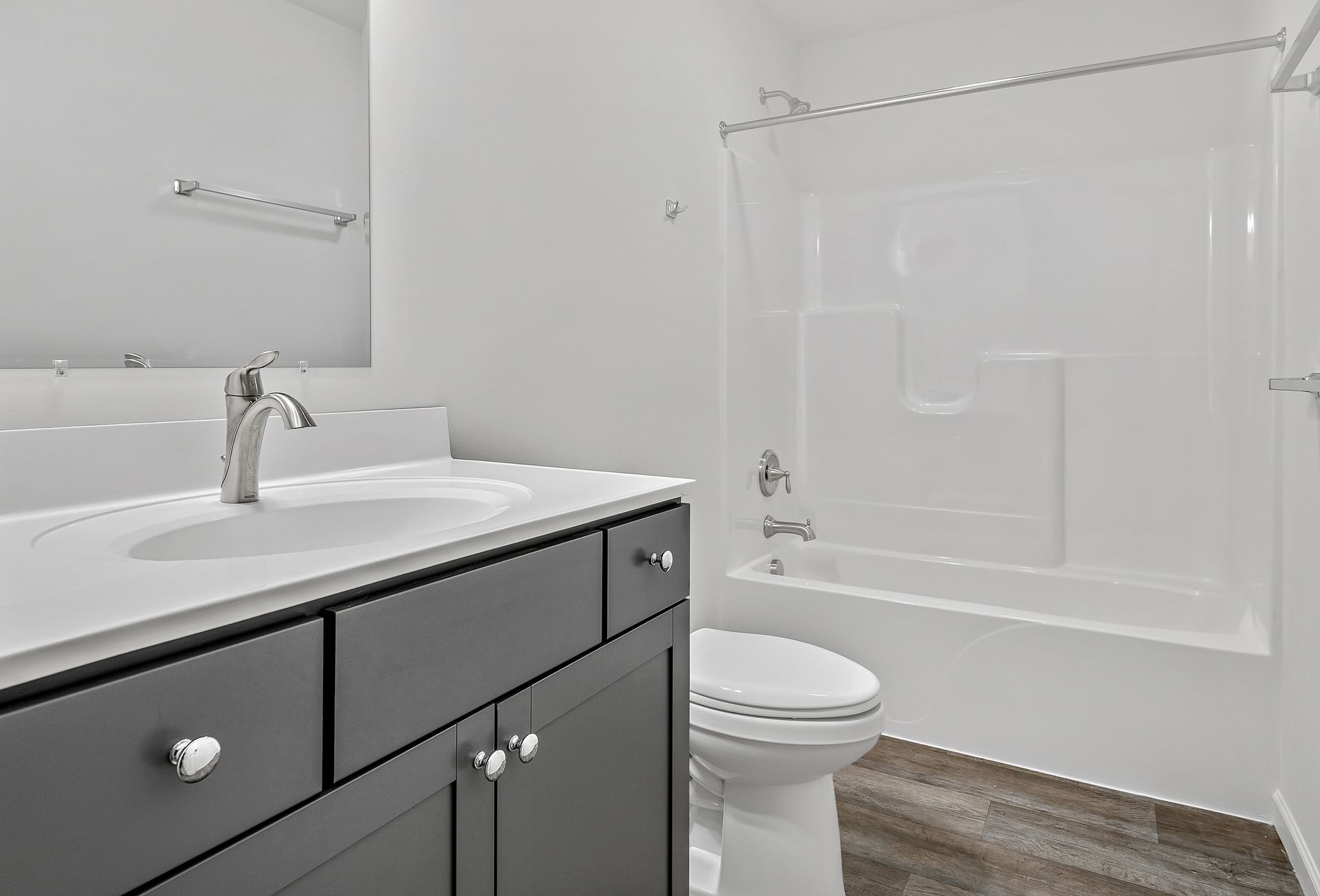 A bathroom with a sink , toilet , bathtub and mirror.