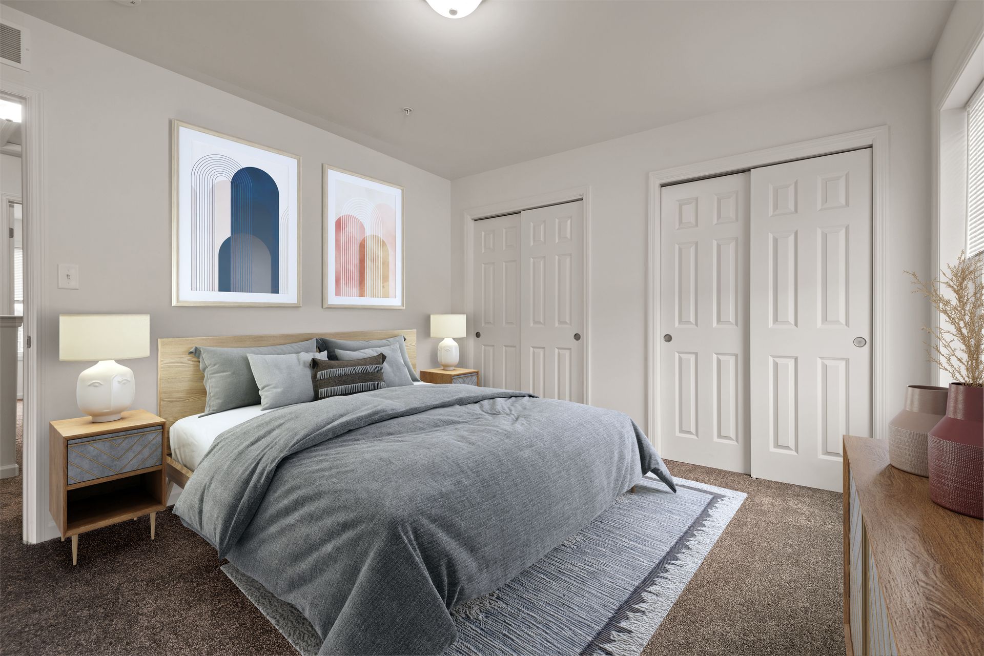 A bedroom with a king size bed , nightstands , lamps and a dresser.
