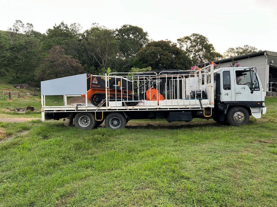 A Large White Truck is Parked in a Grassy Field — NQ Steep Terrain Mulching and Clearing in The Leap, QLD