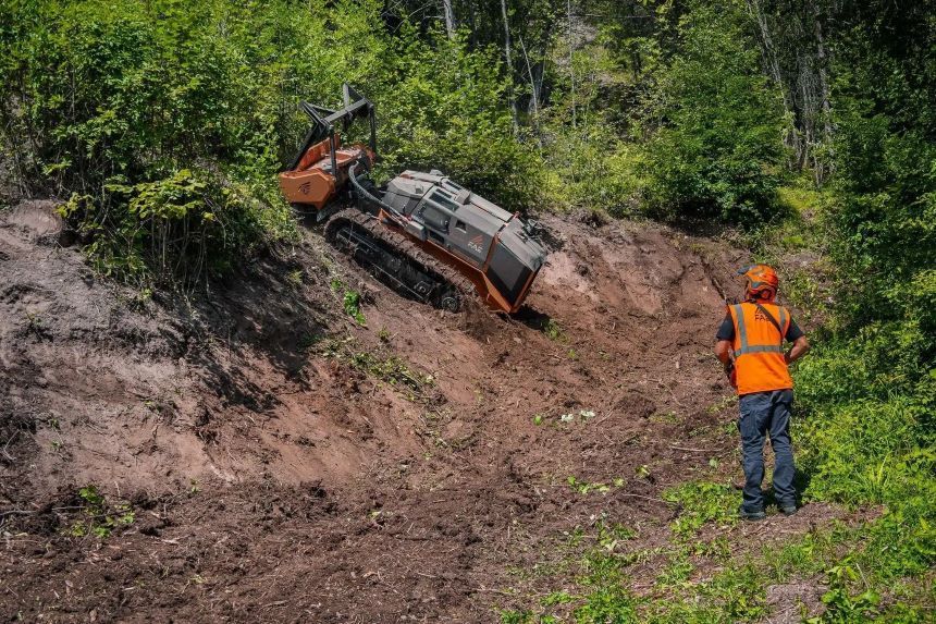 A Man is Standing Next to a Bulldozer in the Woods — NQ Steep Terrain Mulching and Clearing in The Leap, QLD