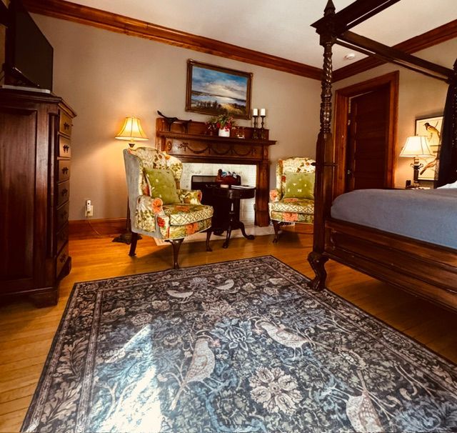 Queen Bee guest room with king bed, fireplace and sitting area at Honeybee Inn