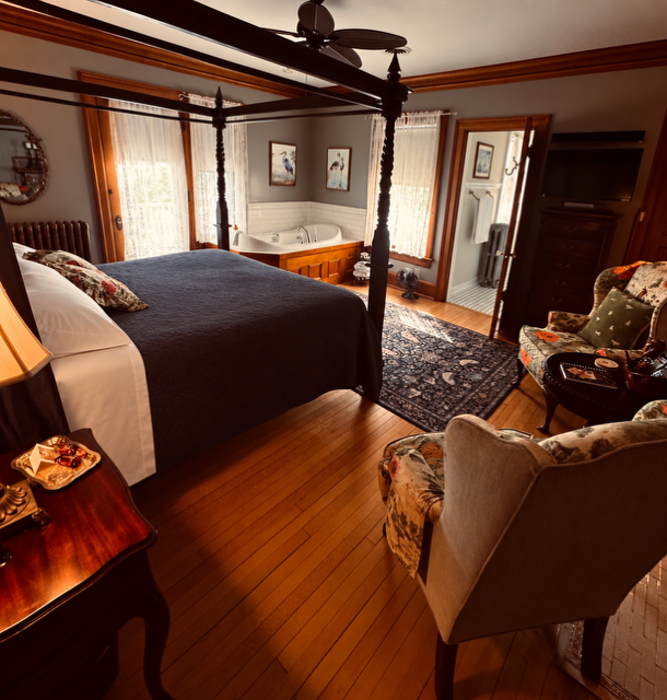 A bedroom with a four poster bed and a ceiling fan