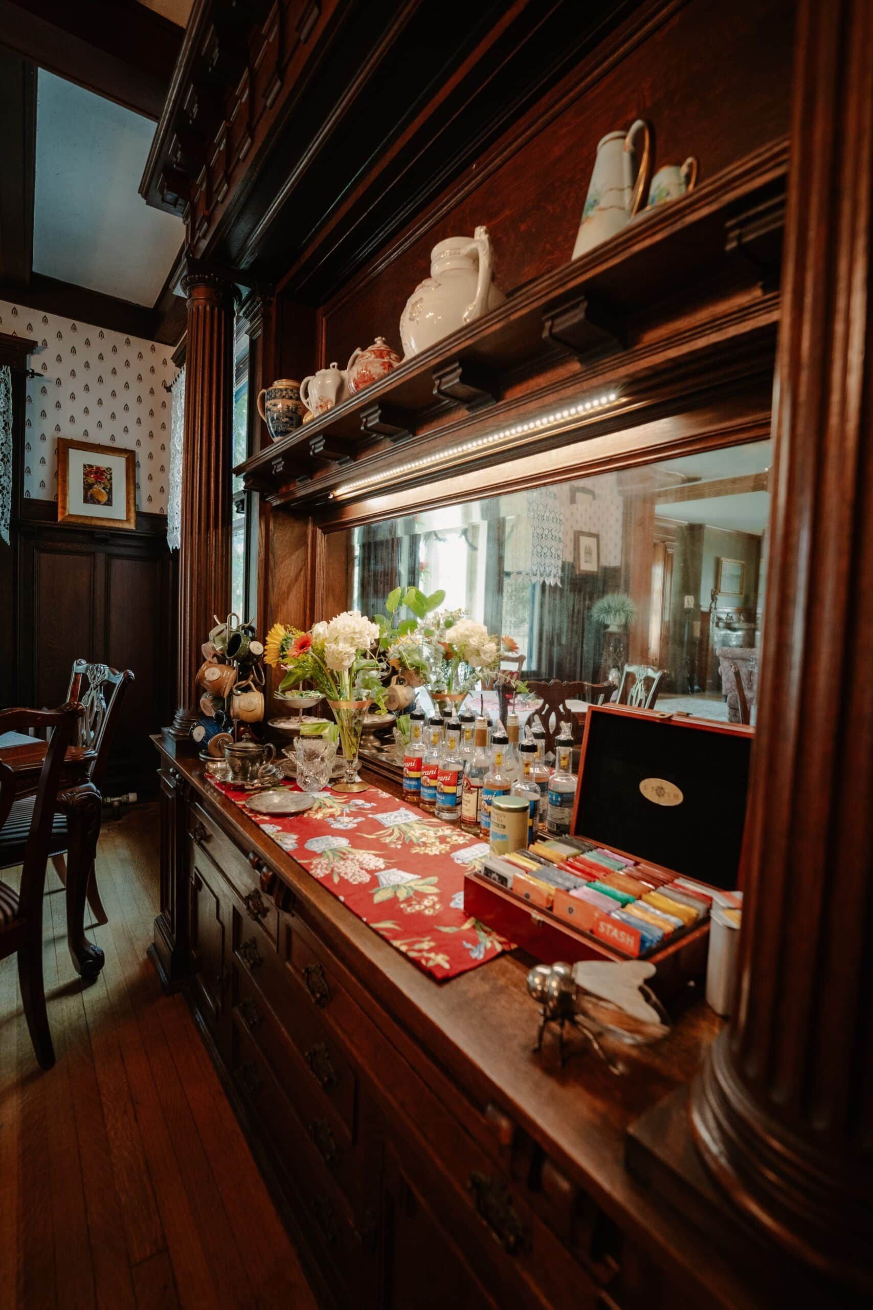 A dining room with a wooden dresser and a mirror.
