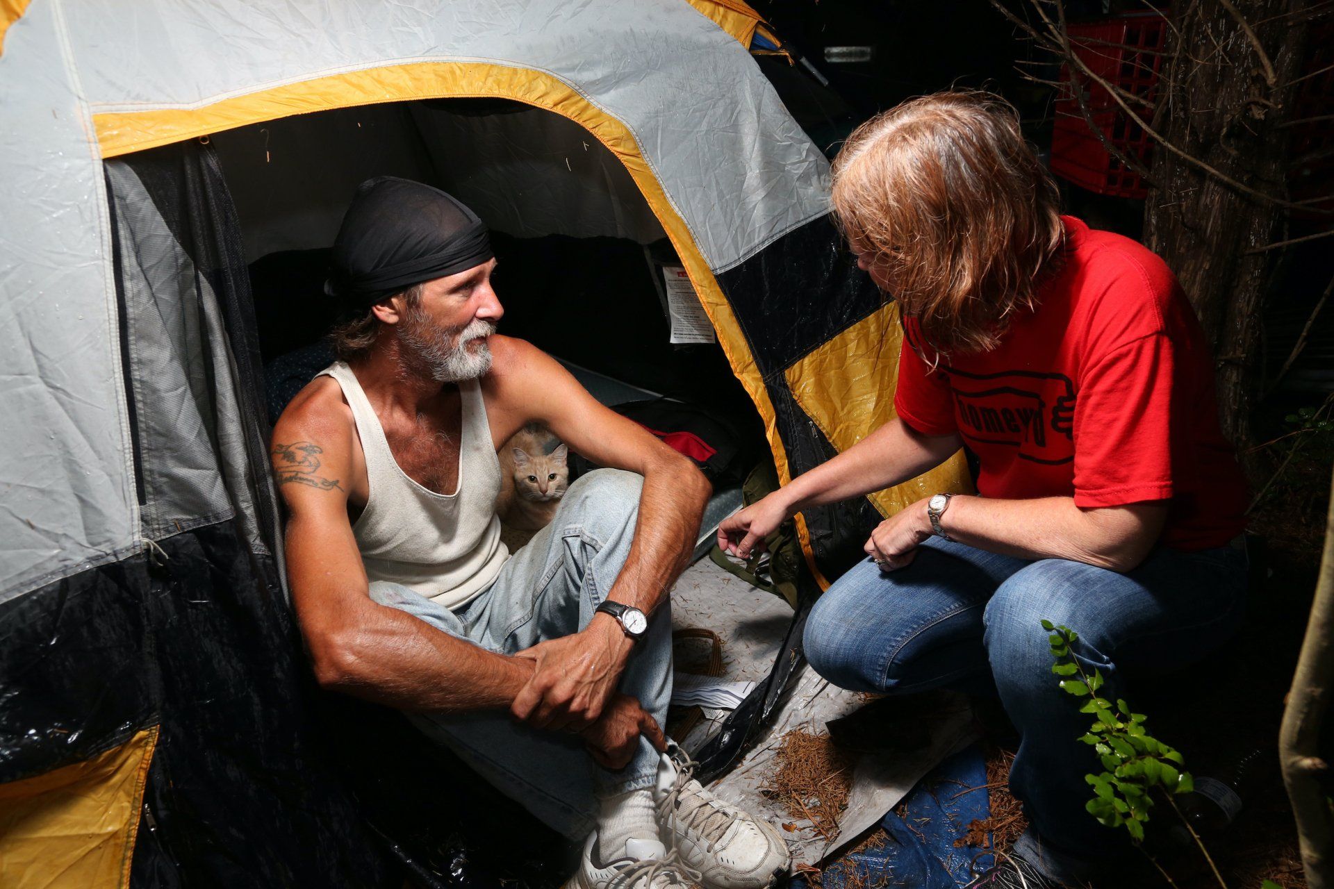 A man is sitting in a tent talking to a woman