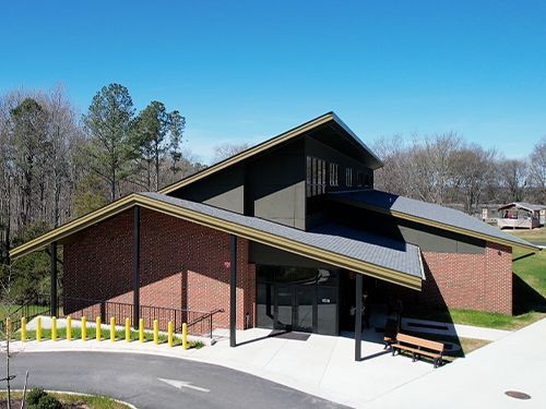 An aerial view of a brick building with a black roof