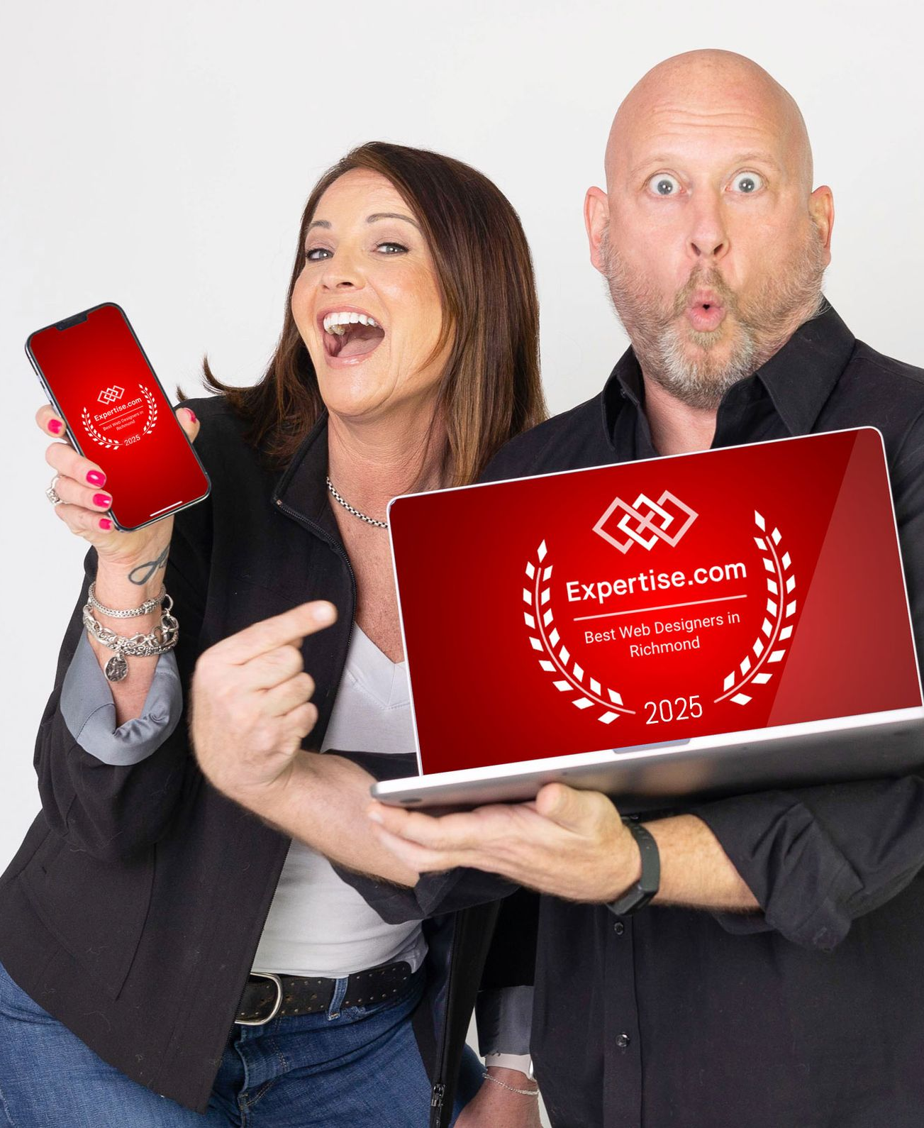 Two people holding a red laptop and matching red phone, smiling against a white background