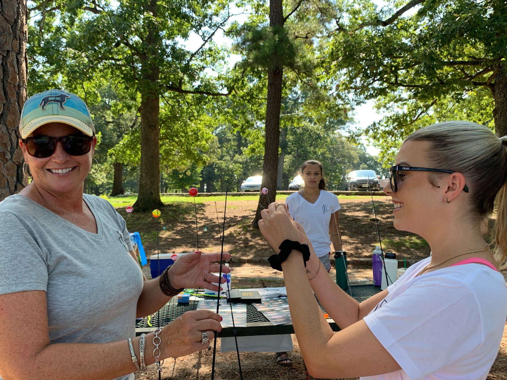 Two women are standing next to each other in a park.