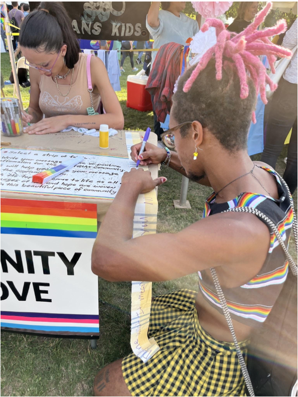 A man sitting at a table with a sign that says nity love