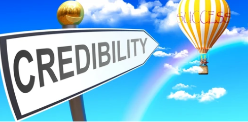 A hot air balloon is flying over a sign that says credibility