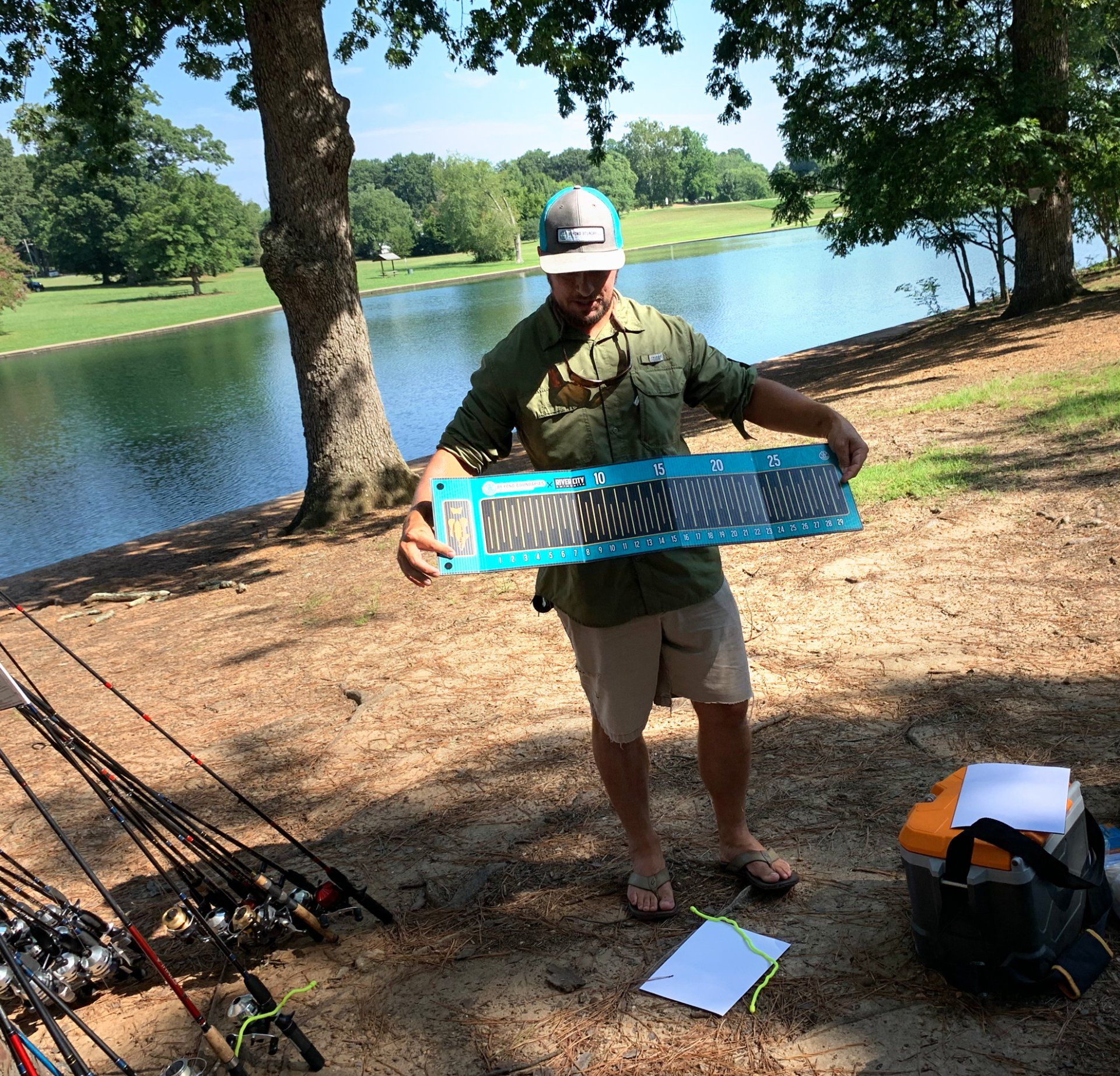 A man is holding a fishing net in front of a lake