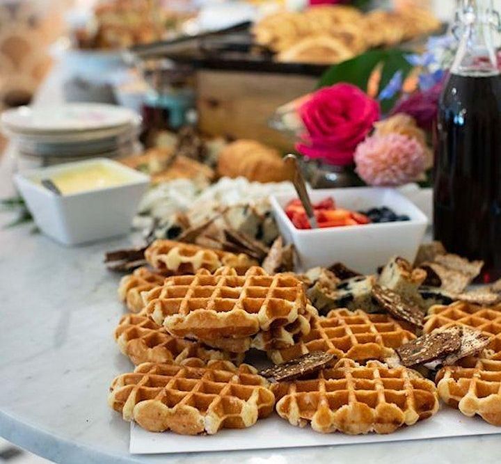 A table topped with waffles and a bowl of berries