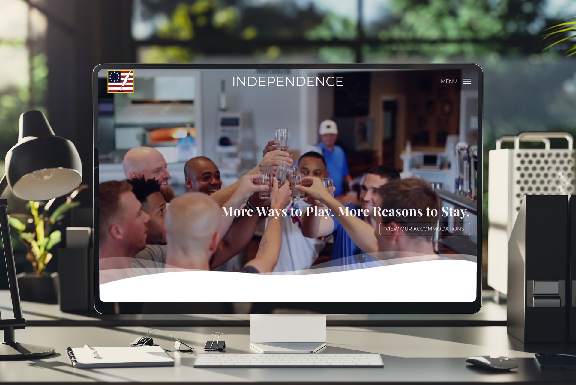 Desktop monitor showing a group video meeting with “INDEPENDENCE” on screen in a bright office