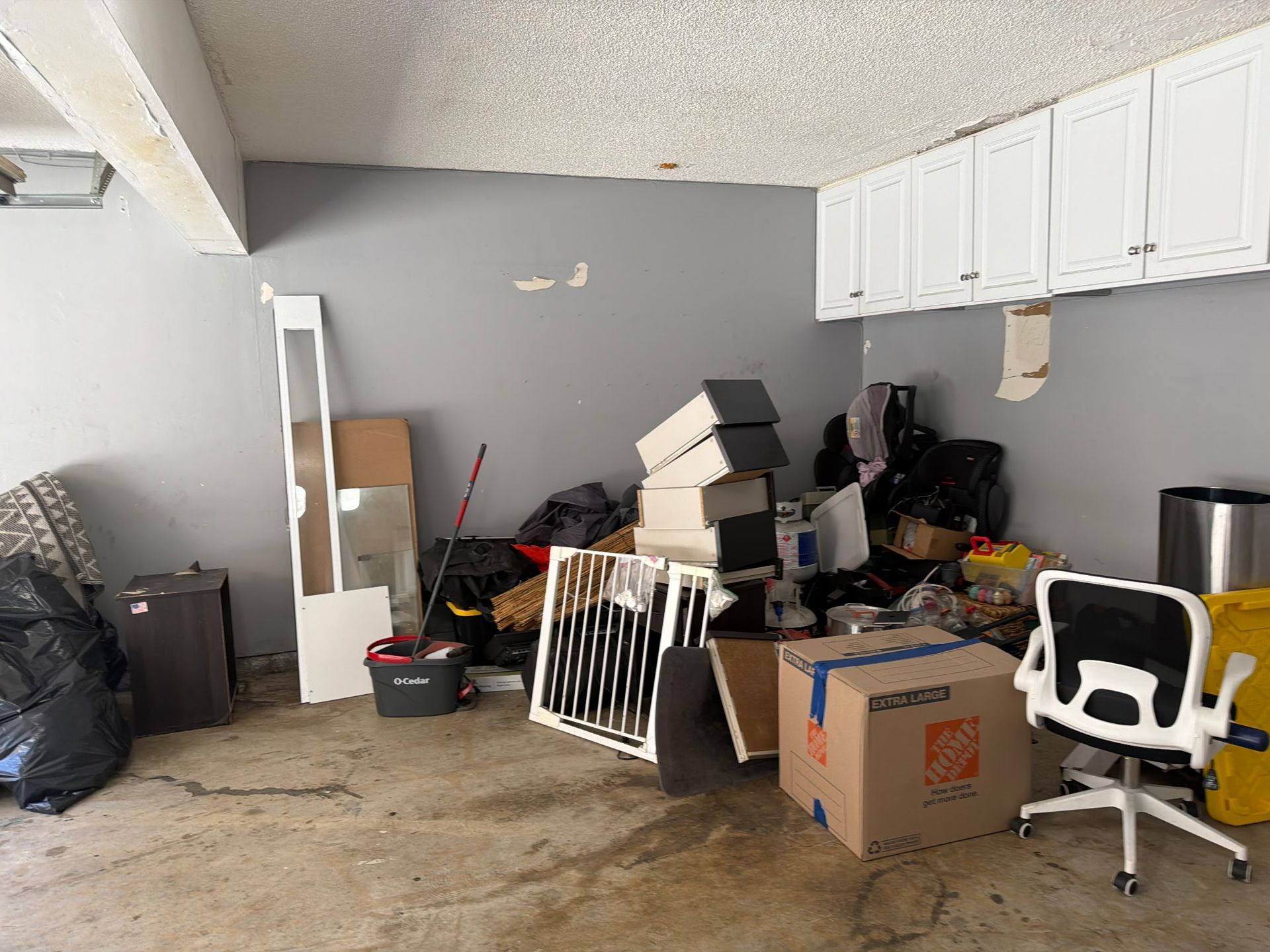 Open garage interior with stored items on shelves, tools, and bicycles hanging.