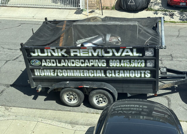 A&D dump trailer with the bed raised, on a dirt surface.
