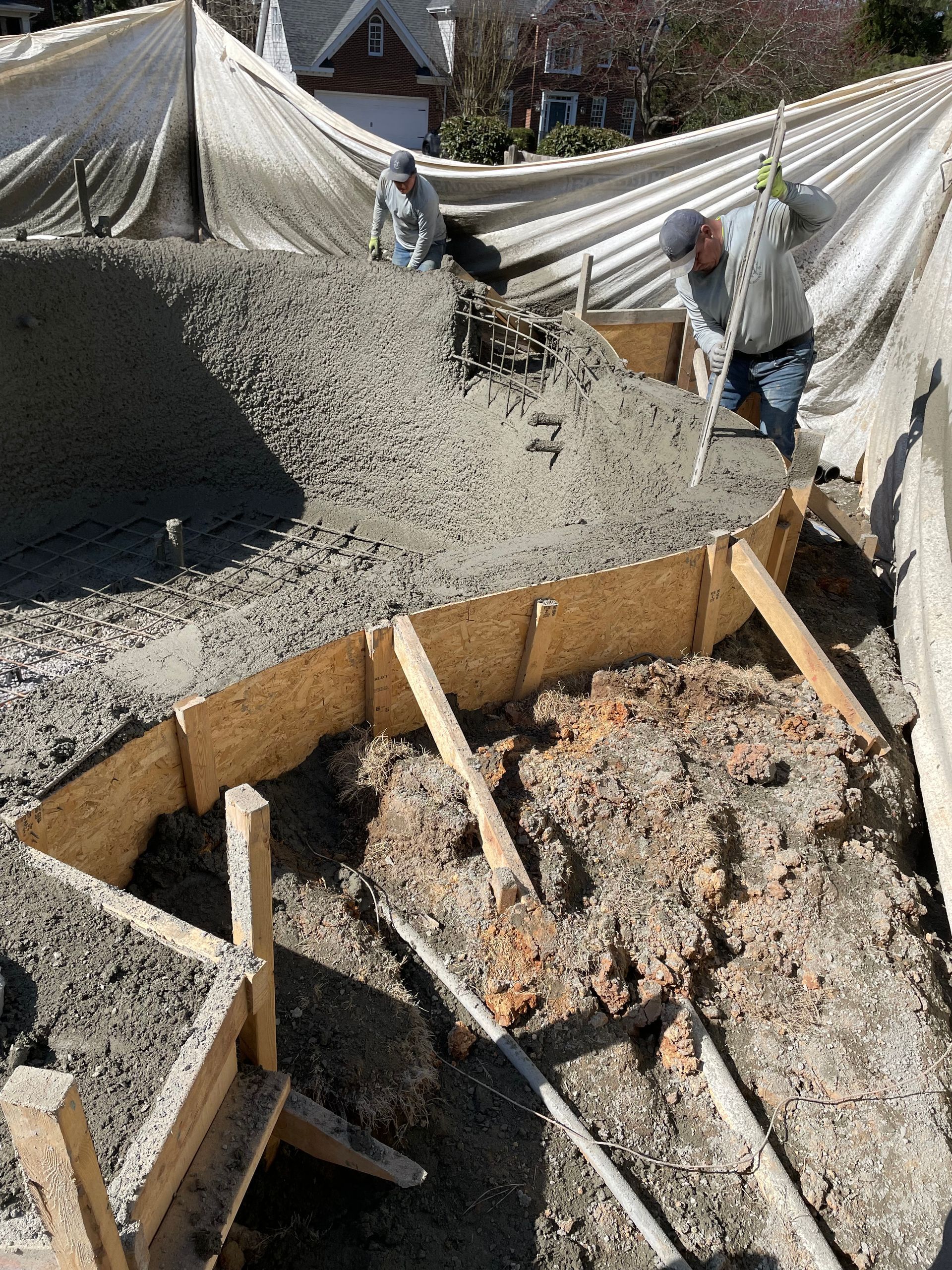 A group of construction workers are working on a pile of concrete.