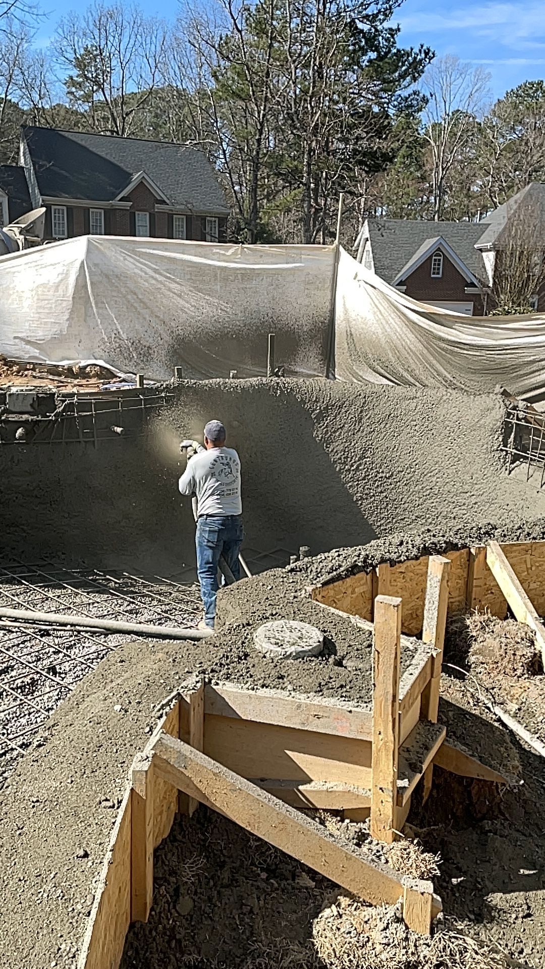 A man is spraying concrete on a construction site.