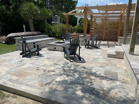 A patio with chairs , a fire pit and a pergola.