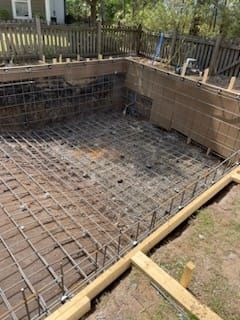 A swimming pool is being built in the backyard of a house.