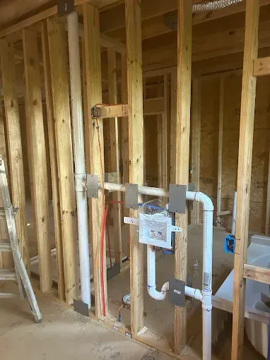 Wooden wall with exposed plumbing for a new construction project.