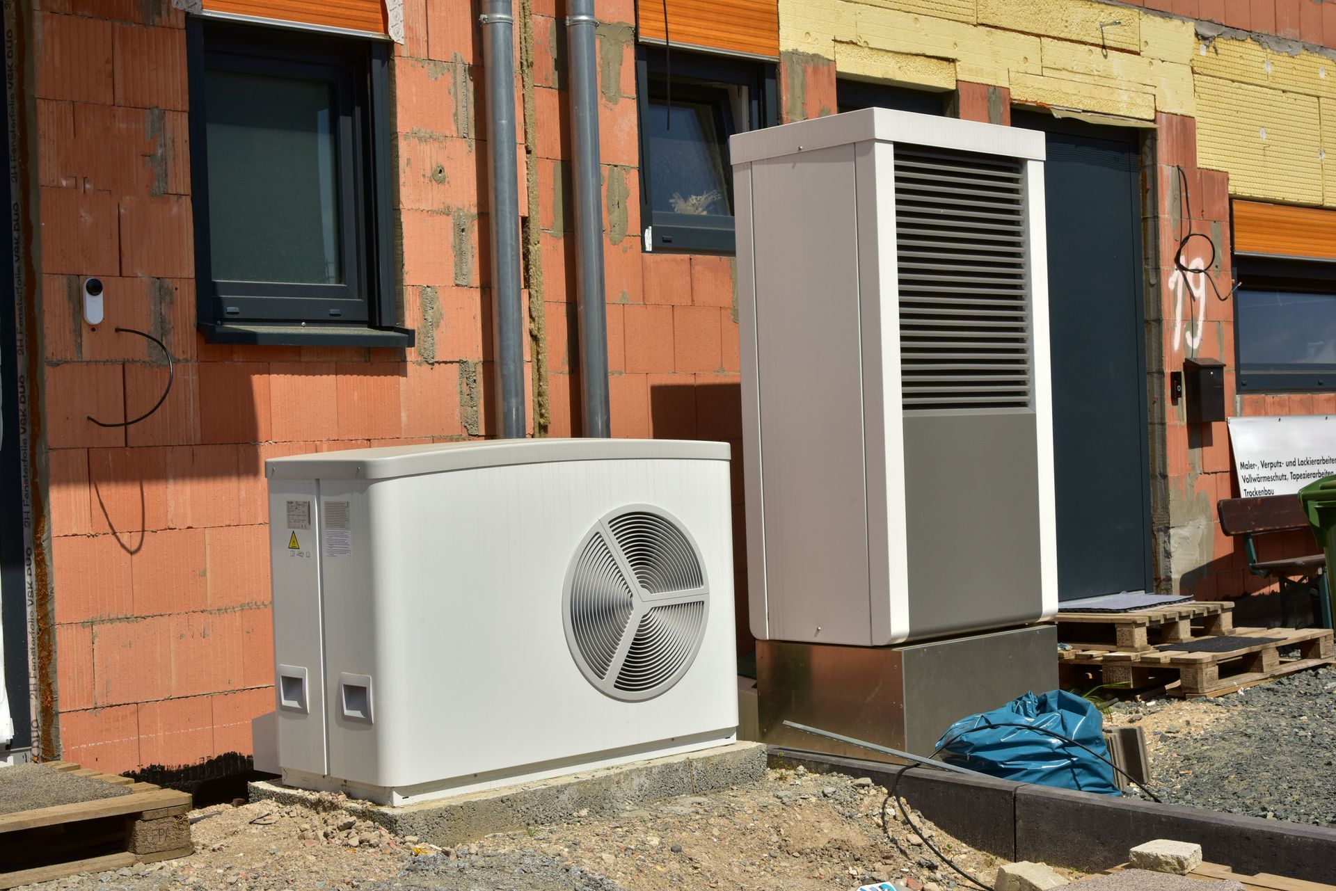 Heat pump outdoor units installed beside a home — Andy's Heating and Cooling serves Omaha, NE homeowners comparing heat pump vs. furnace options