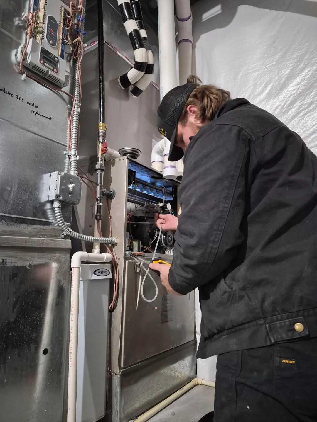 HVAC technician inspecting a blower fan after no airflow and a burning smell were