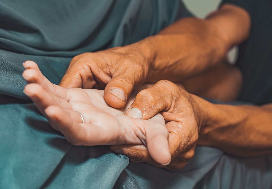 Hands holding an outstretched foot against a teal cloth background