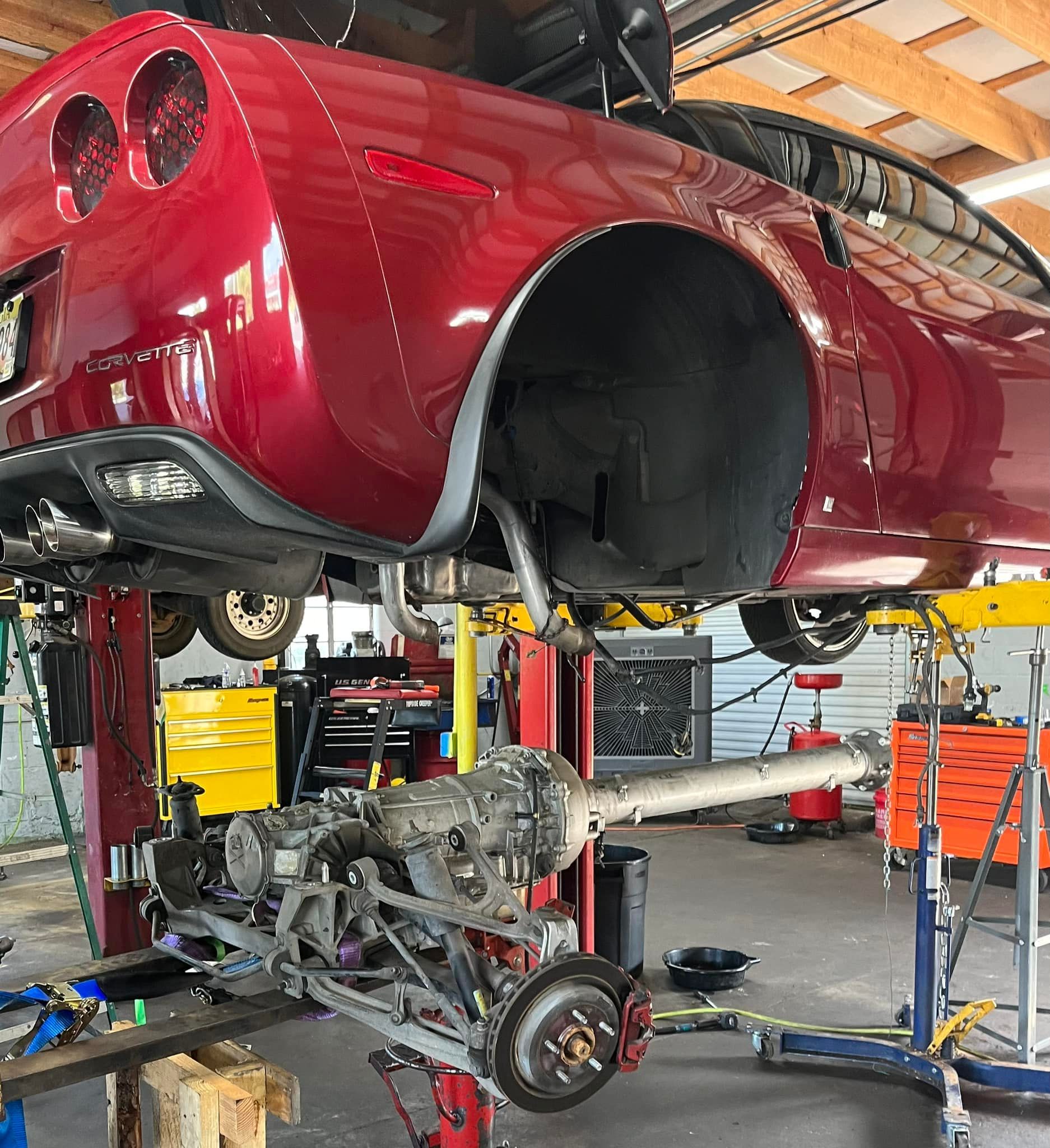 Red Sports Car On Lift For Brake And Suspension Service | Modern Automotive