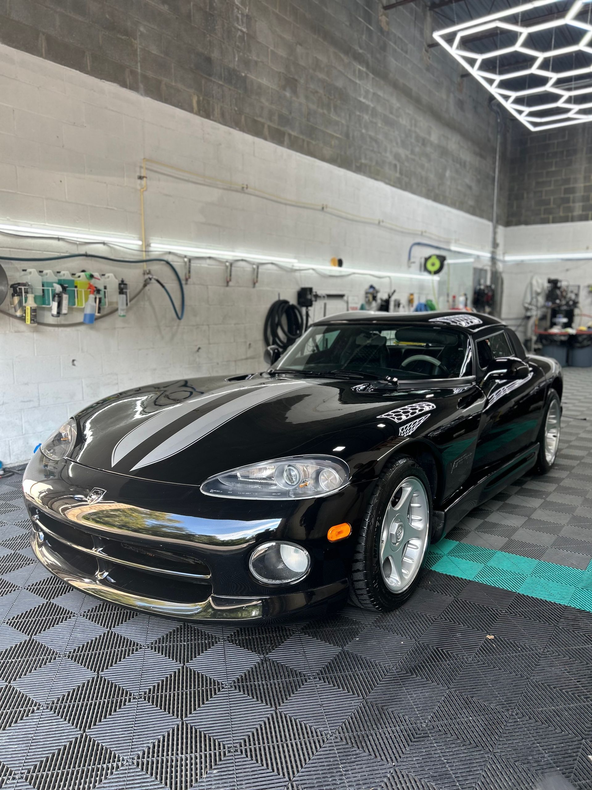A black ford mustang is parked in a parking lot.